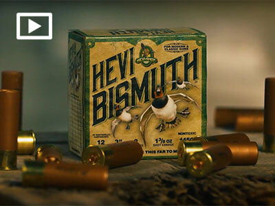HEVI-Bismuth sitting on a table with shotshells scattered around with a play button overlay