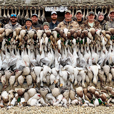 hunters behind massive stack of waterfowl