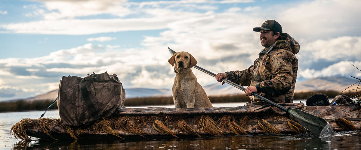 hunter and hunting dog in a canoe