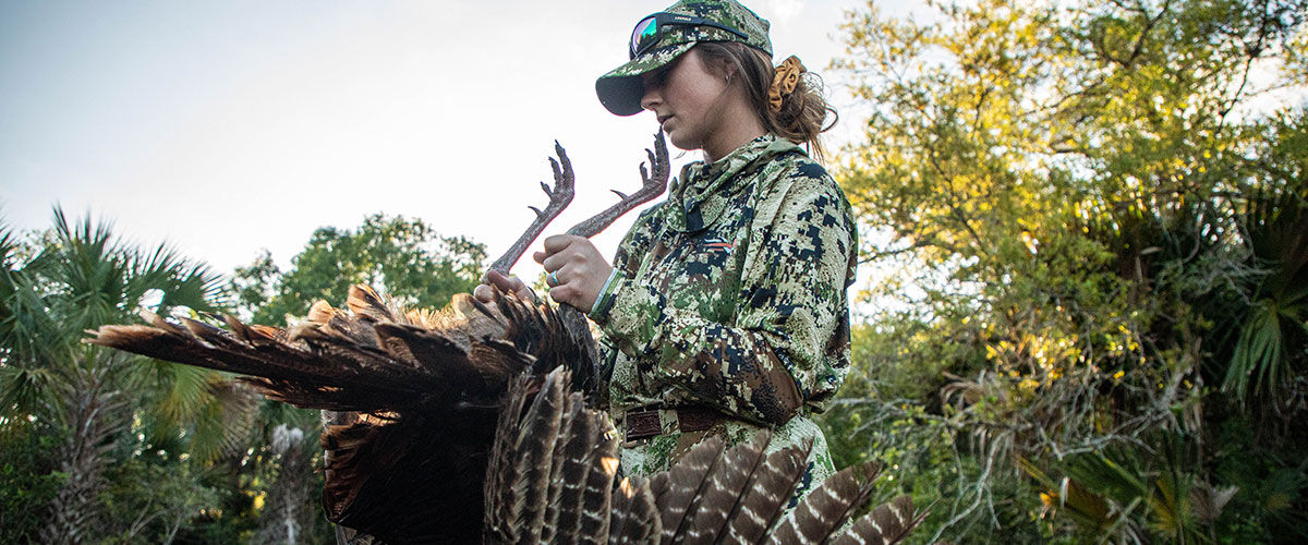 hunter carrying turkey by its legs
