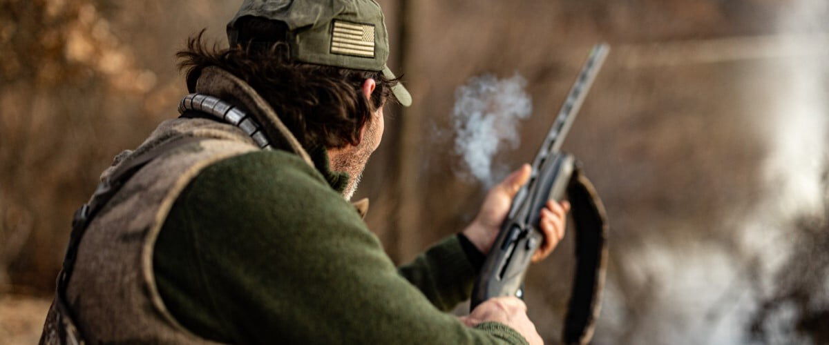 hunter shooting a shotgun