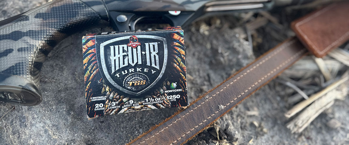 shotgun on the ground with a box of HEVI-18 Turkey